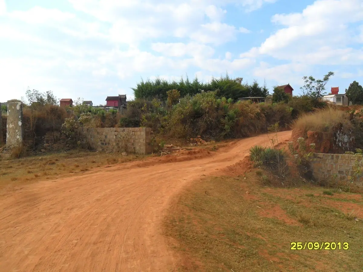Chemin de terre rouge menant au portail sud du village d'Ambohimalaza